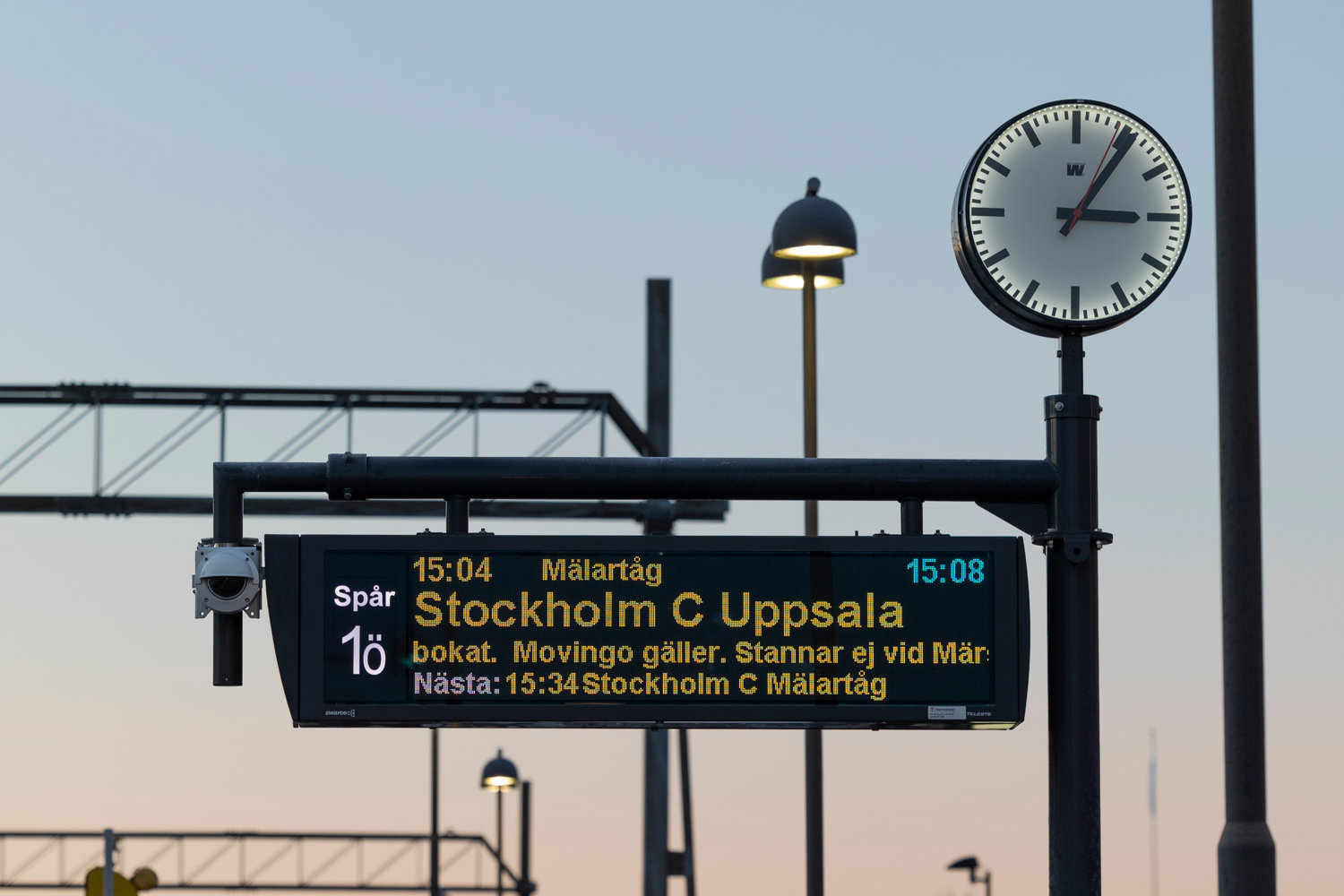 skylt med avgångstid för tåget på plattform