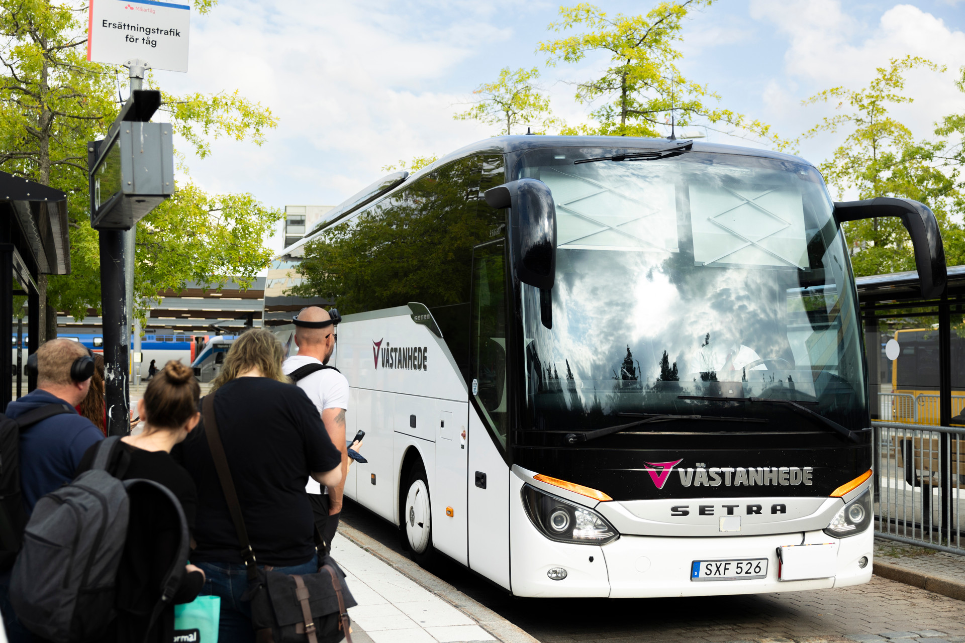 En grupp människor som väntar på att få gå på en ersättningsbuss.