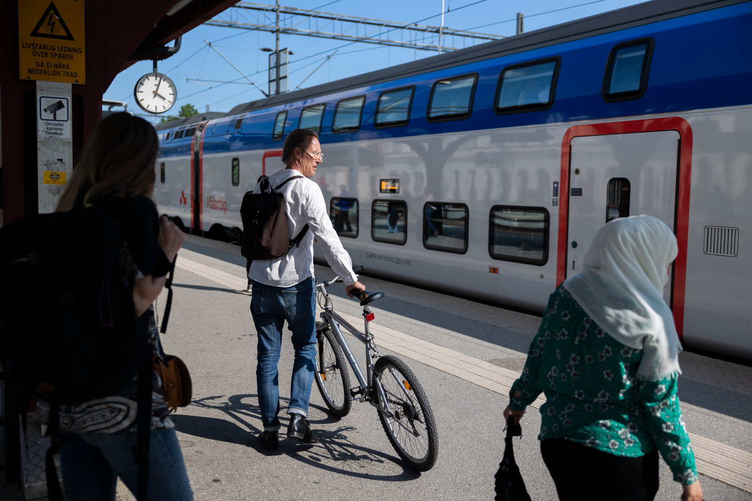 Man with a bike next to a Mälartåg