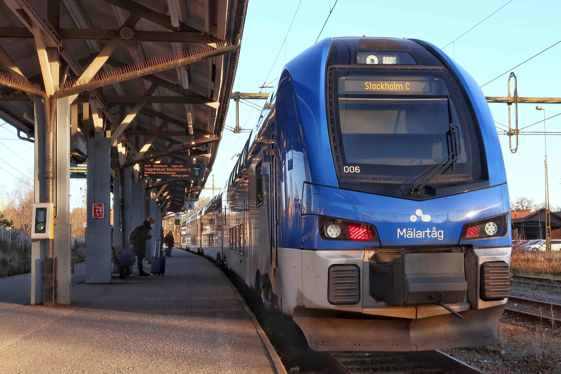 Ett Mälartåg som kör in på en tågstation