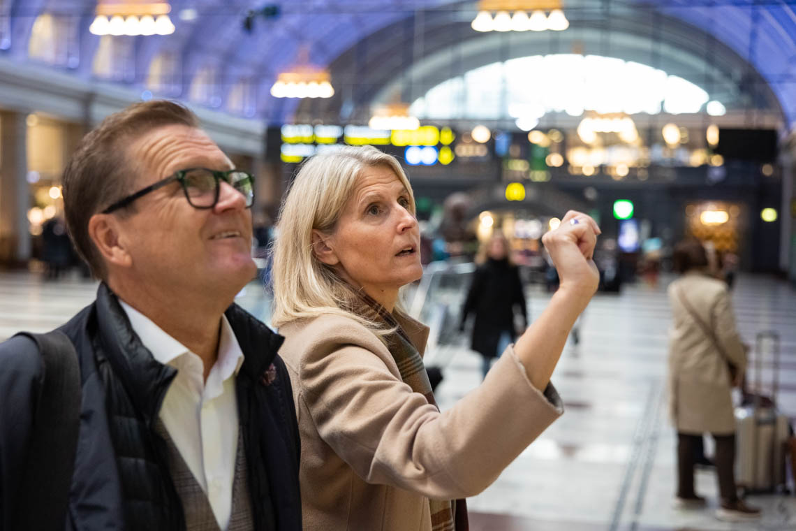 Två personer tittar på informationstavlan på Stockholm centralstation