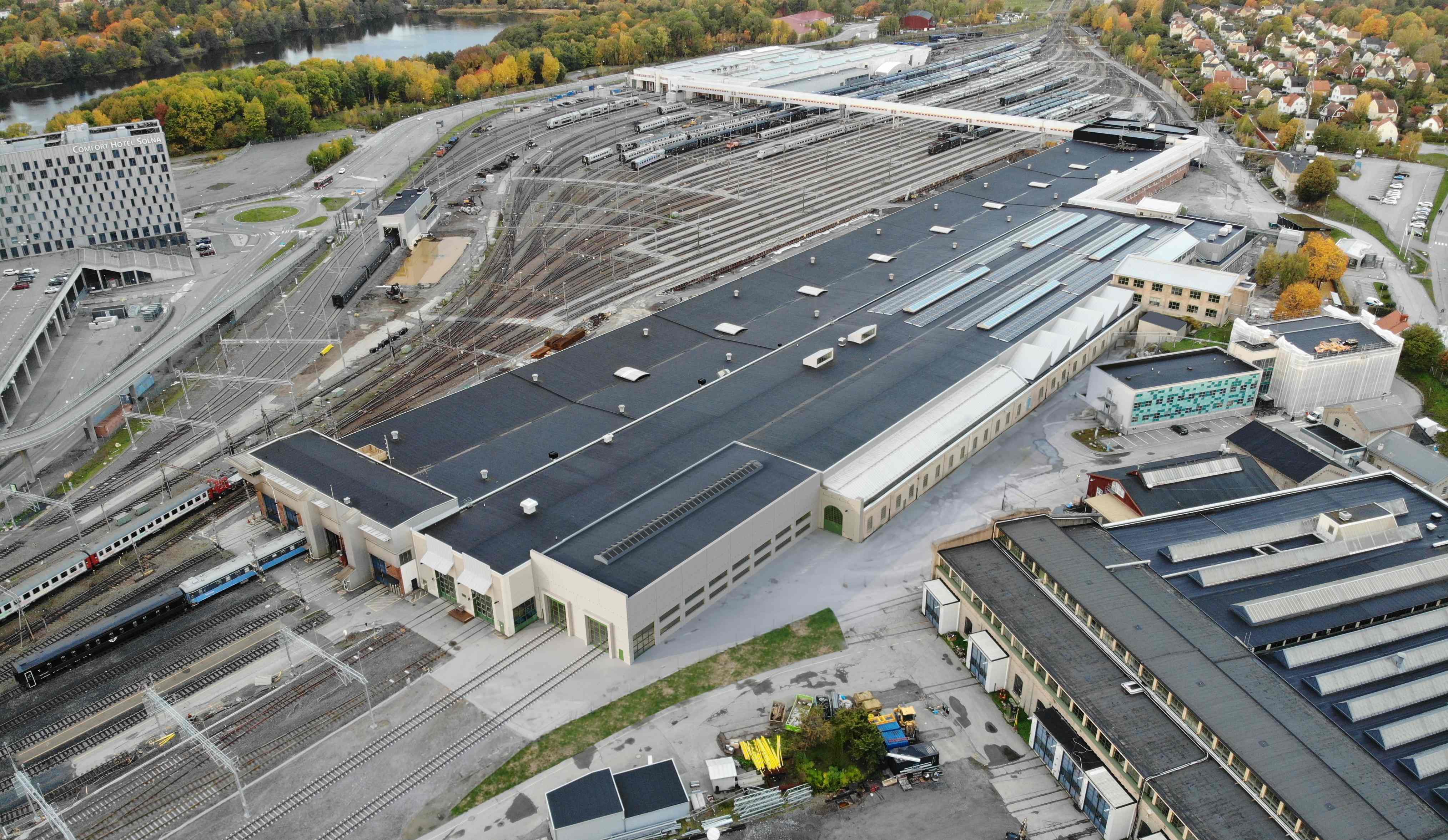 Flygbild över verkstadslokaler med spår och tåg 